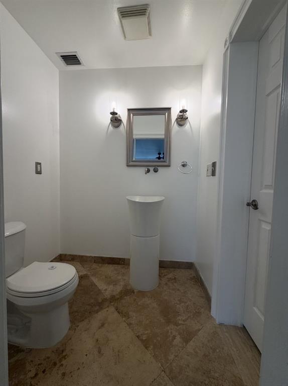 2650 Northeast 52nd Street Lighthouse Point, FL 33064 - Photo 28 of 35 a bathroom with a toilet a sink and mirror