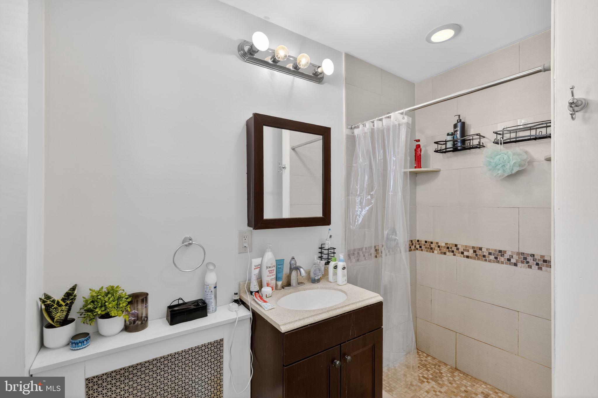 1229 South 6th Street Philadelphia, PA 19147 - Photo 22 of 36 a bathroom with a sink a mirror and a shower