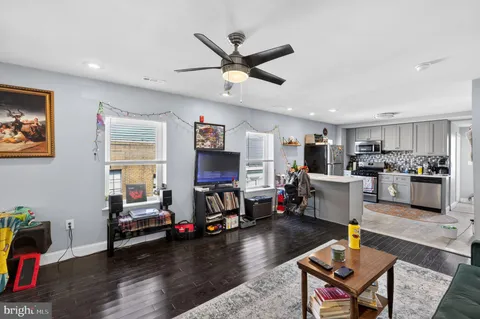 a living room with furniture kitchen view and a window