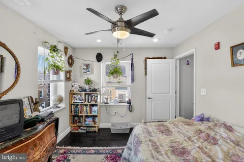 a bedroom that has a bed and a bookshelf with wooden floor