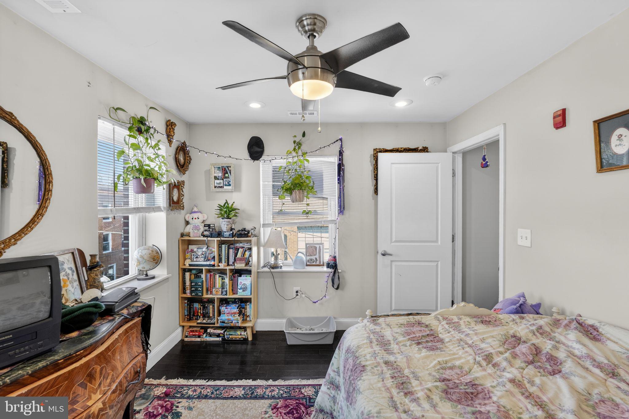 1229 South 6th Street Philadelphia, PA 19147 - Photo 30 of 36 a bedroom that has a bed and a bookshelf with wooden floor