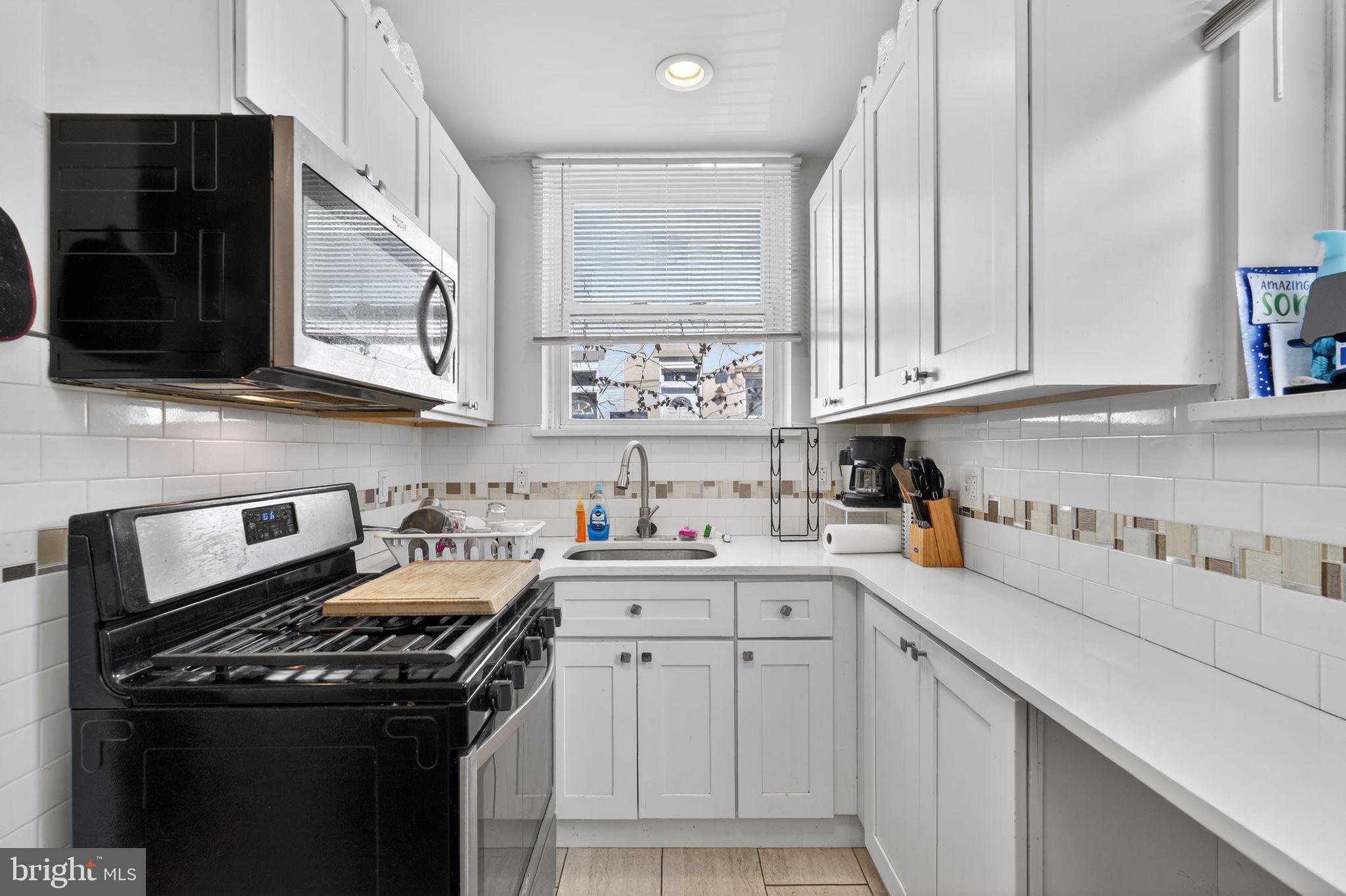 1229 South 6th Street Philadelphia, PA 19147 - Photo 6 of 36 a kitchen with stainless steel appliances granite countertop a sink stove and cabinets