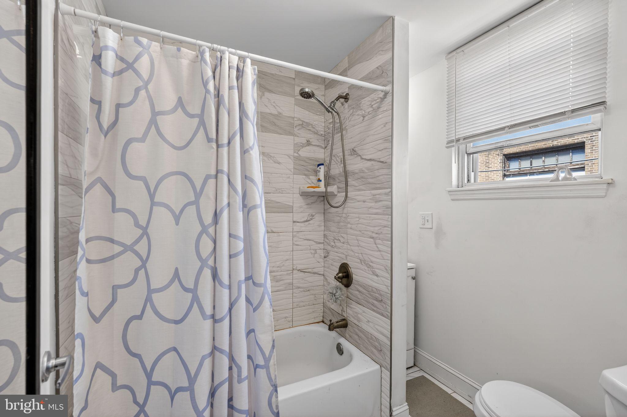 1229 South 6th Street Philadelphia, PA 19147 - Photo 10 of 36 a bathroom with a shower curtain and a toilet