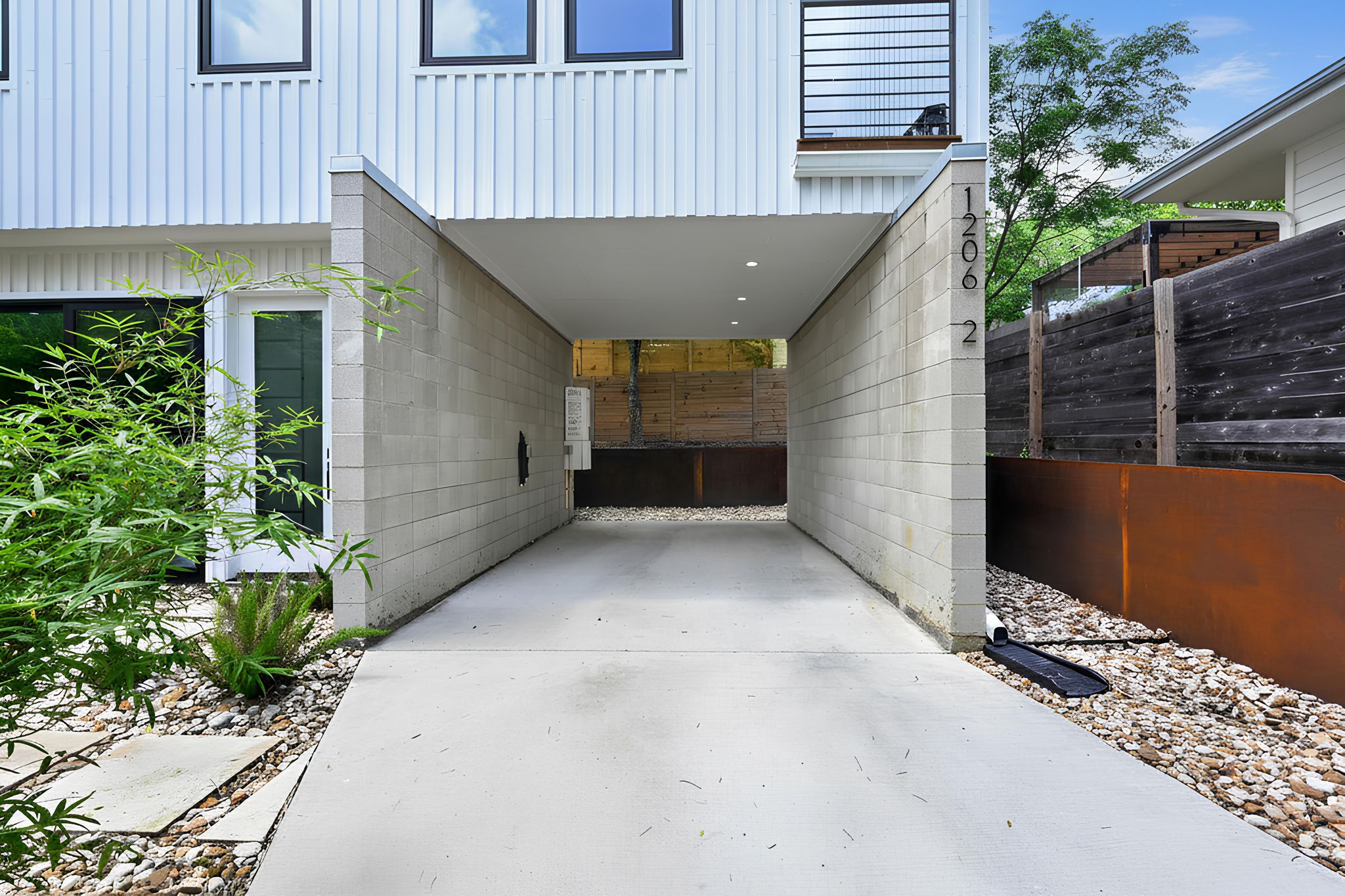 1206 Luna Street, Unit 2 Austin, TX 78721 - Photo 8 of 30 The property features a concrete driveway leading to a covered parking area with recessed lighting