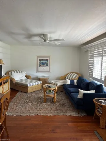a living room with furniture wooden floor and window