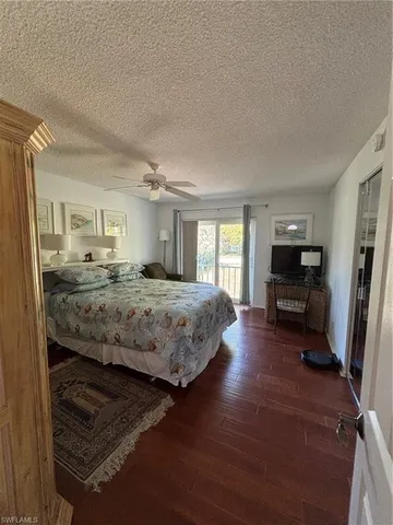 a bedroom with a large bed and a flat tv screen on dresser