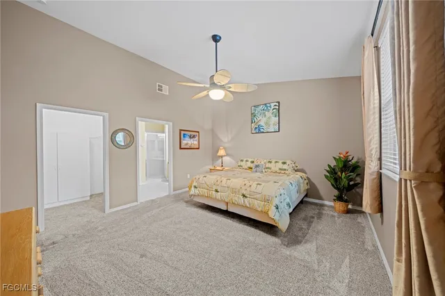 a spacious bedroom with a bed and a chandelier