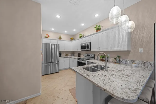 a kitchen with stainless steel appliances granite countertop a sink refrigerator and cabinets