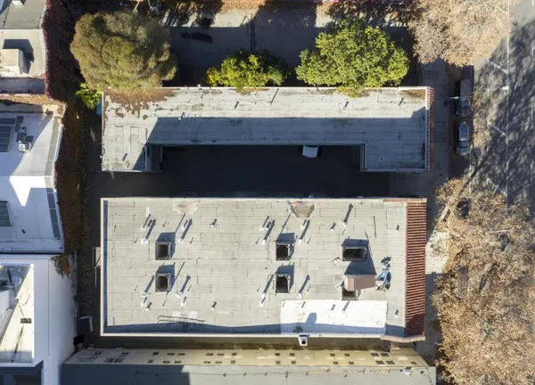 a view of a house with a yard and potted plants