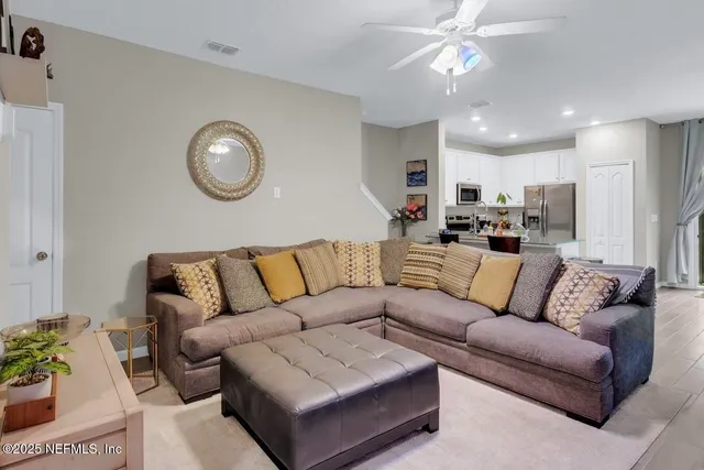 a living room with furniture kitchen and a chandelier