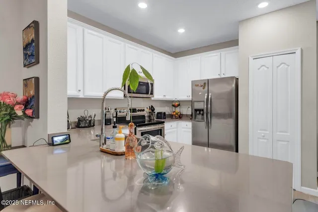 a kitchen with a refrigerator and a counter top space