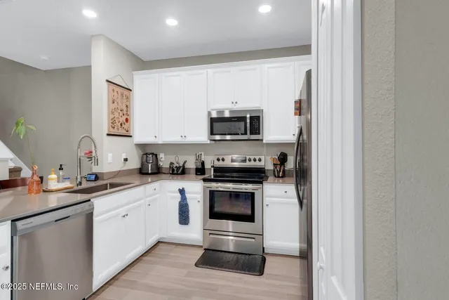 a kitchen with stainless steel appliances granite countertop a stove a sink and a microwave