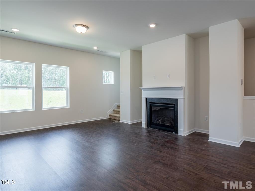 4035 Mahal Avenue Cary, NC 27519 - Photo 13 of 29 an empty room with wooden floor fireplace and windows