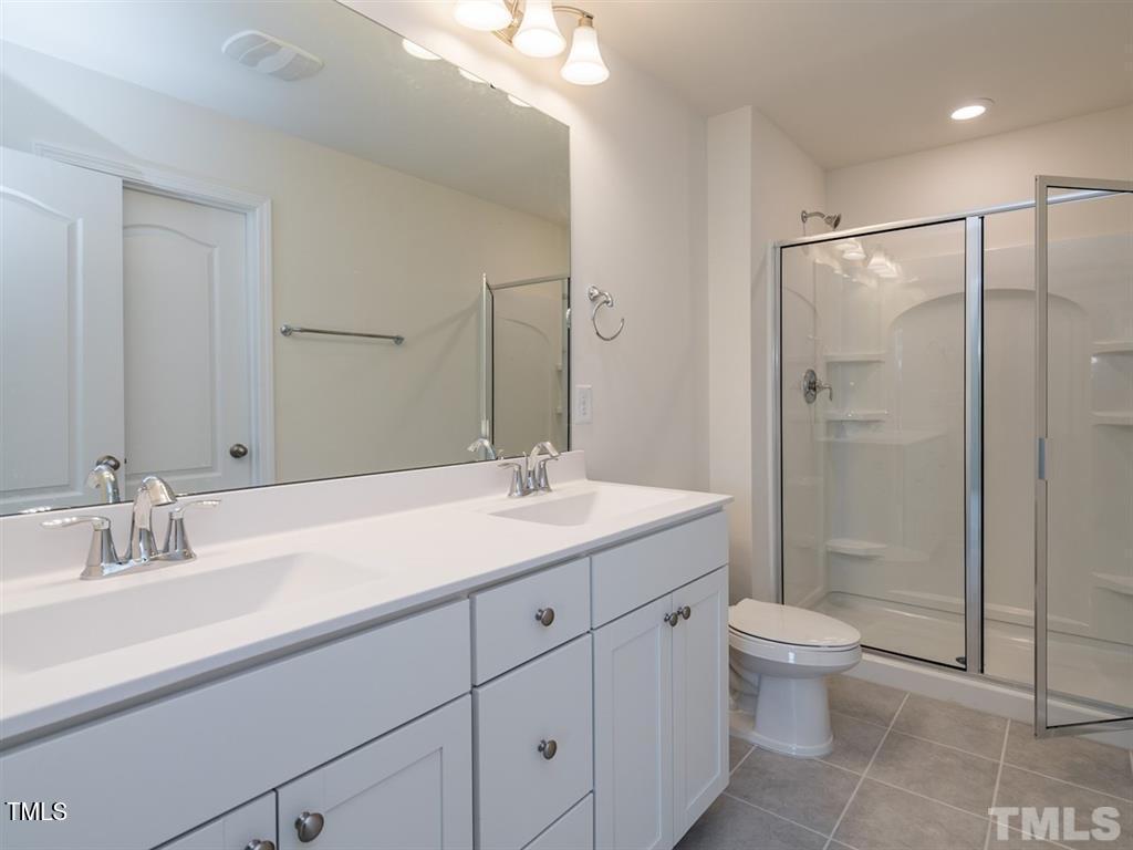 4035 Mahal Avenue Cary, NC 27519 - Photo 17 of 29 a bathroom with a double vanity sink toilet and shower