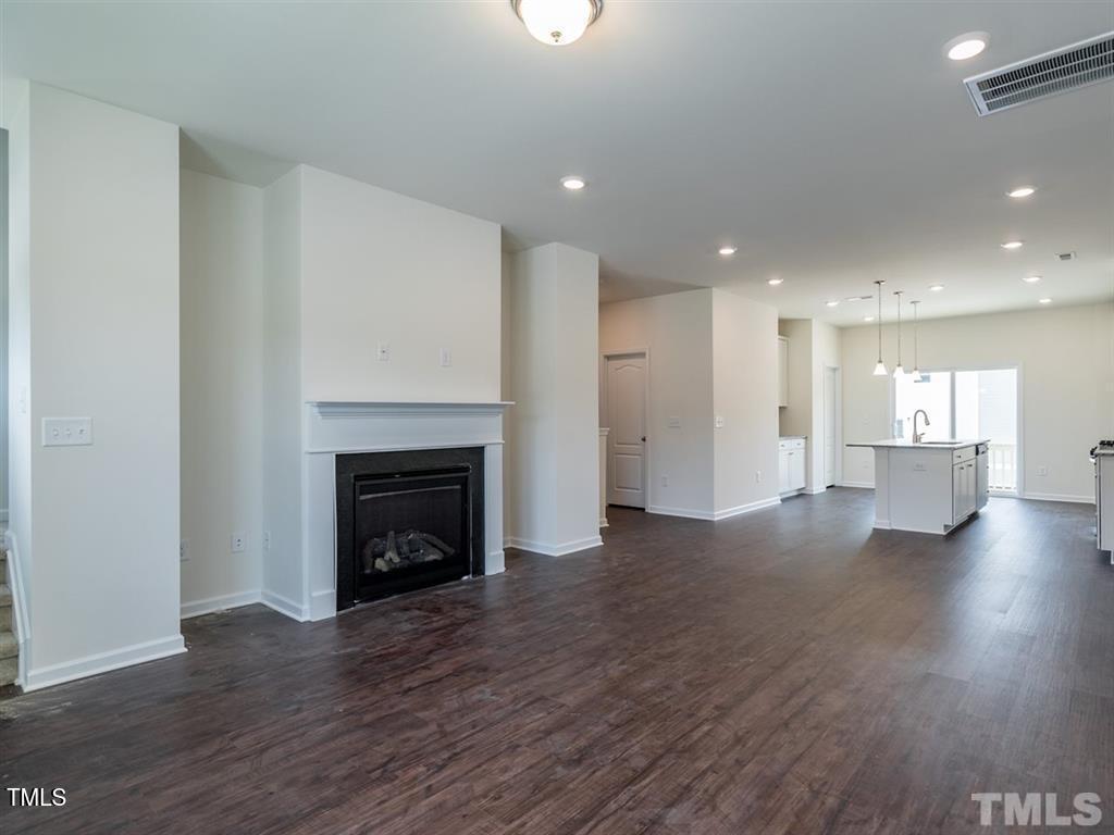 4035 Mahal Avenue Cary, NC 27519 - Photo 5 of 29 a view of an empty room with wooden floor and a fireplace