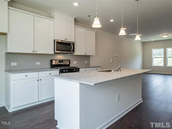 a kitchen with a sink stove and cabinets