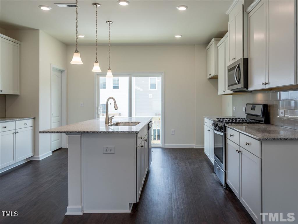 4035 Mahal Avenue Cary, NC 27519 - Photo 10 of 29 a kitchen with stainless steel appliances granite countertop a sink a stove and a wooden floors