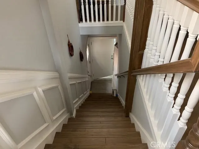 a view of a hallway with wooden floor and staircase