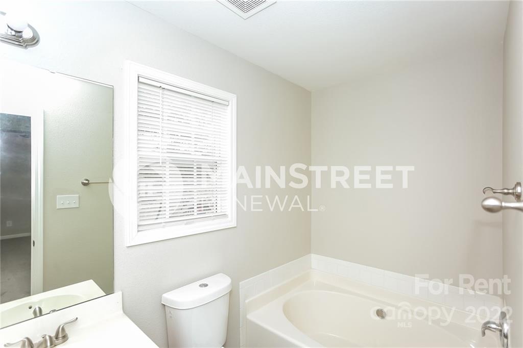 8566 Filbert Lane Charlotte, NC 28215 - Photo 11 of 32 a bathroom with a bathtub and a toilet