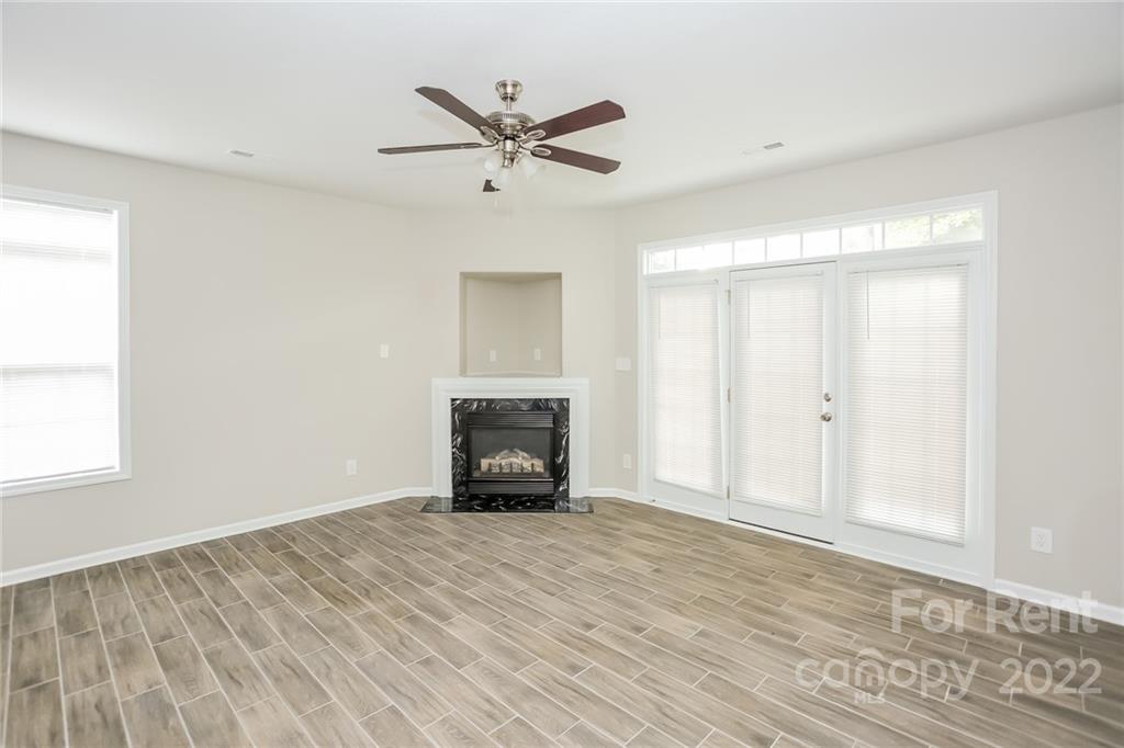 8566 Filbert Lane Charlotte, NC 28215 - Photo 21 of 32 a view of empty room with wooden floor and fireplace