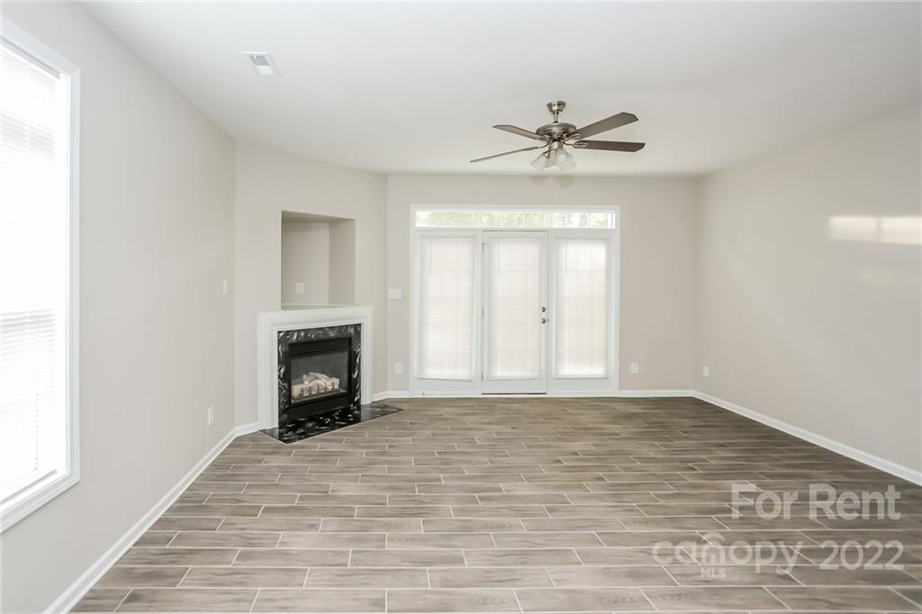 8566 Filbert Lane Charlotte, NC 28215 - Photo 22 of 32 a view of an empty room with a fireplace and a window