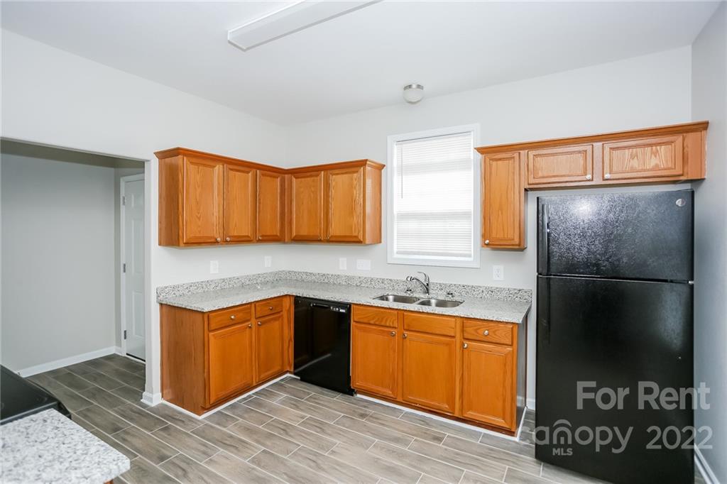 8566 Filbert Lane Charlotte, NC 28215 - Photo 23 of 32 a kitchen with stainless steel appliances granite countertop a refrigerator a sink and a stove