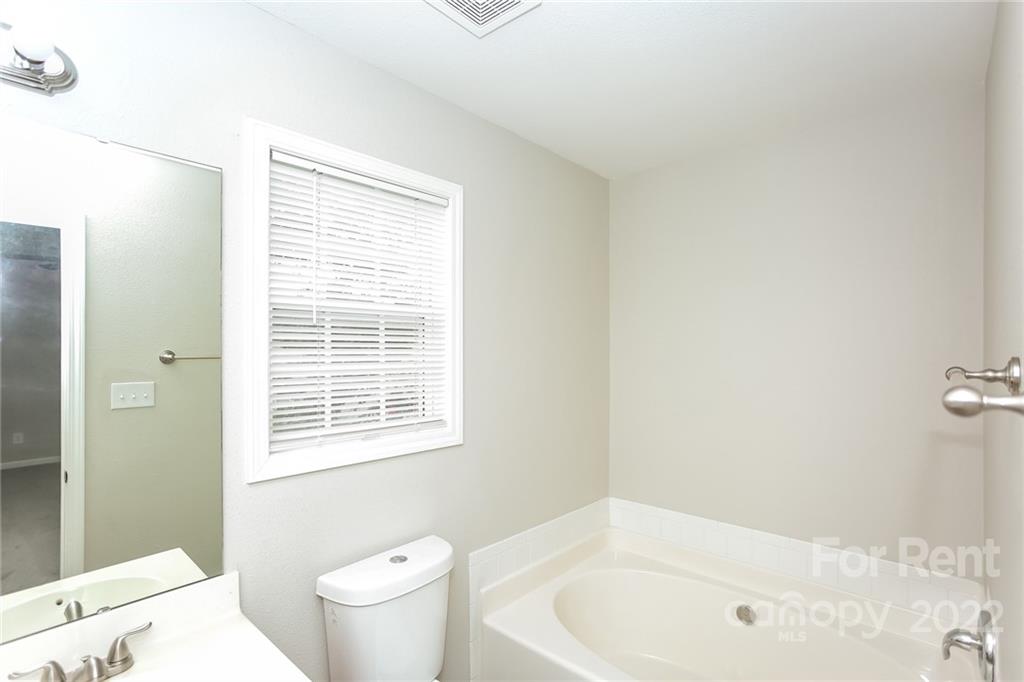 8566 Filbert Lane Charlotte, NC 28215 - Photo 26 of 32 a bathroom with a bathtub and a toilet