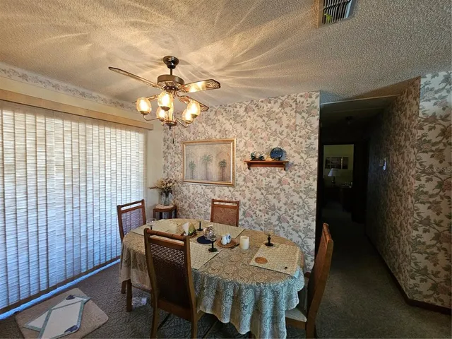 a view of a dining room with furniture and a chandelier