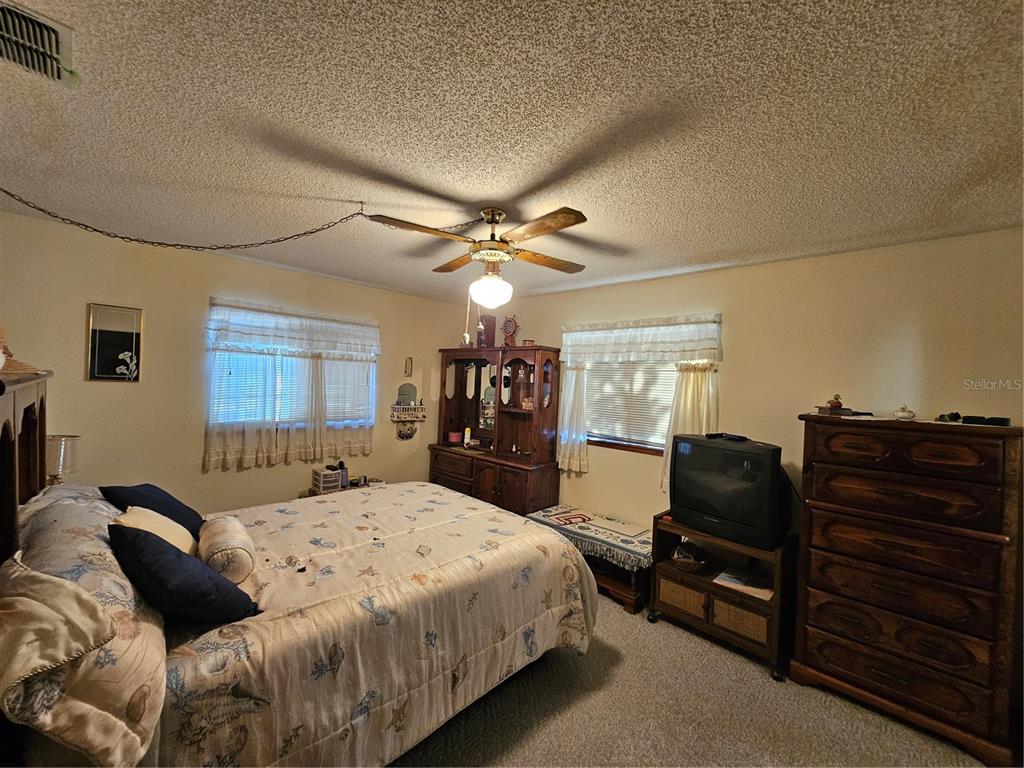 9115 Southwest 102nd Lane Ocala, FL 34481 - Photo 16 of 30 a bedroom with a bed and dresser