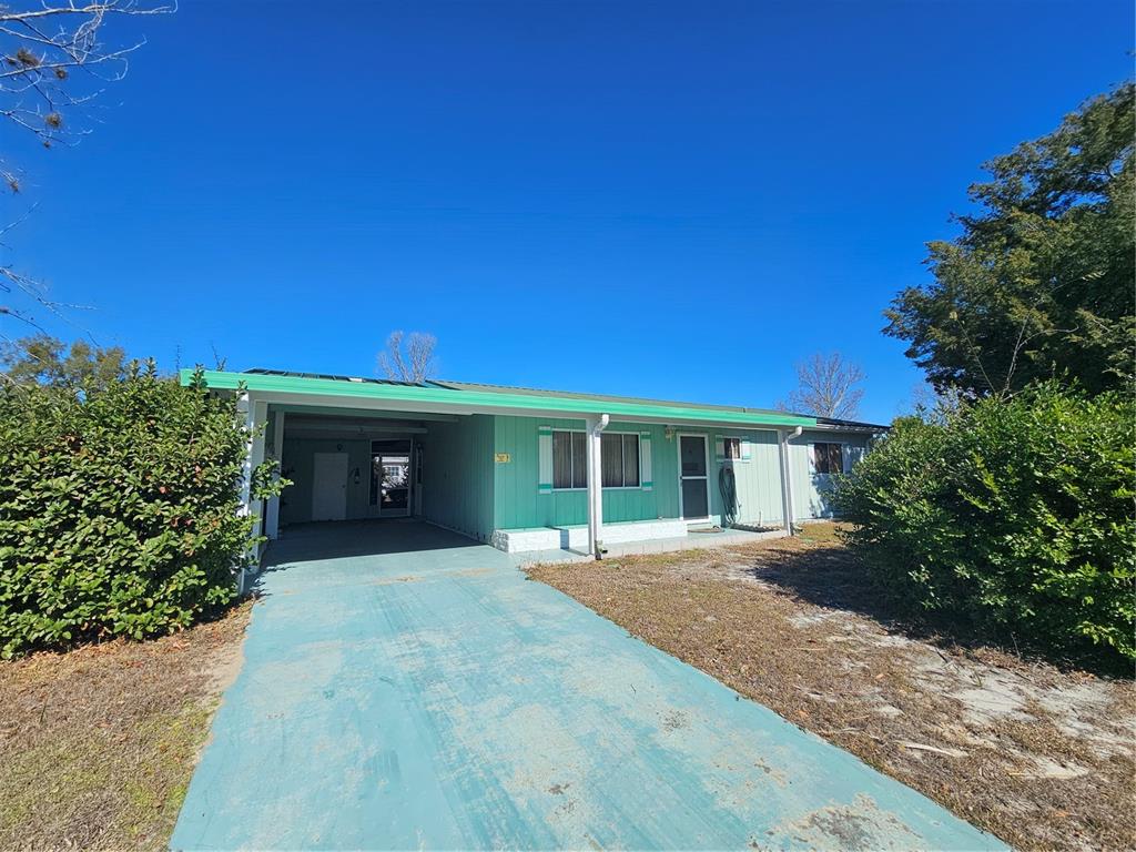 9115 Southwest 102nd Lane Ocala, FL 34481 - Photo 2 of 30 a front view of a house with a yard and trees