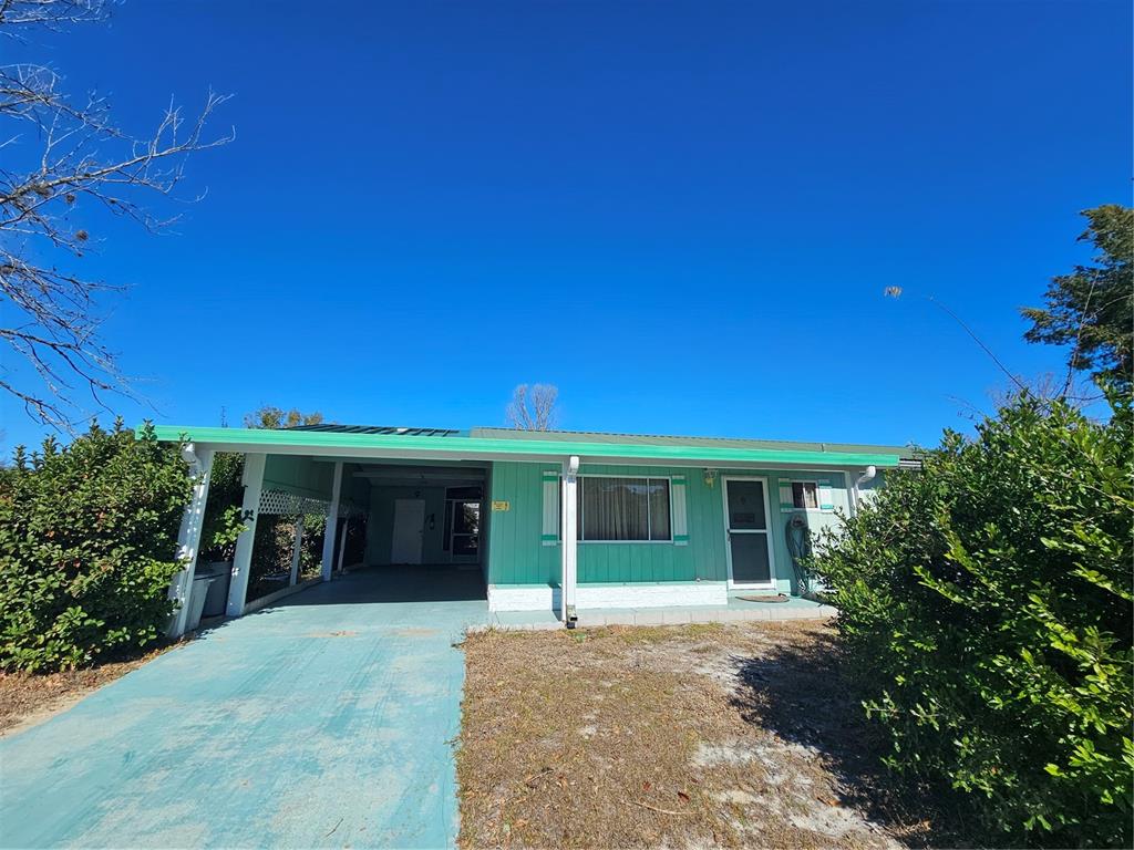 9115 Southwest 102nd Lane Ocala, FL 34481 - Photo 4 of 30 front view of a house with a yard and trees