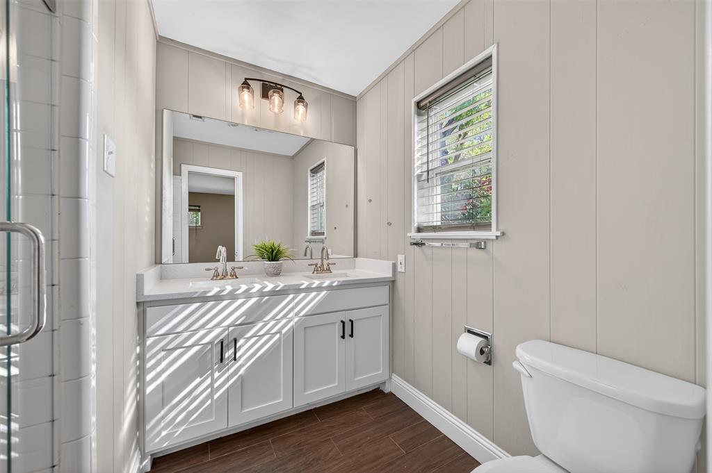 5008 Marble Falls Road Fort Worth, TX 76103 - Photo 14 of 33 a spacious bathroom with a granite countertop toilet a sink and a mirror