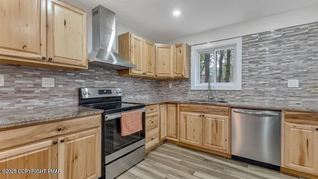 a kitchen with stainless steel appliances granite countertop a sink a stove and cabinets