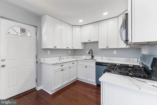 a kitchen with granite countertop white cabinets and white appliances