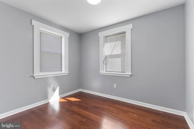 a view of a room that has wooden floor and windows in it