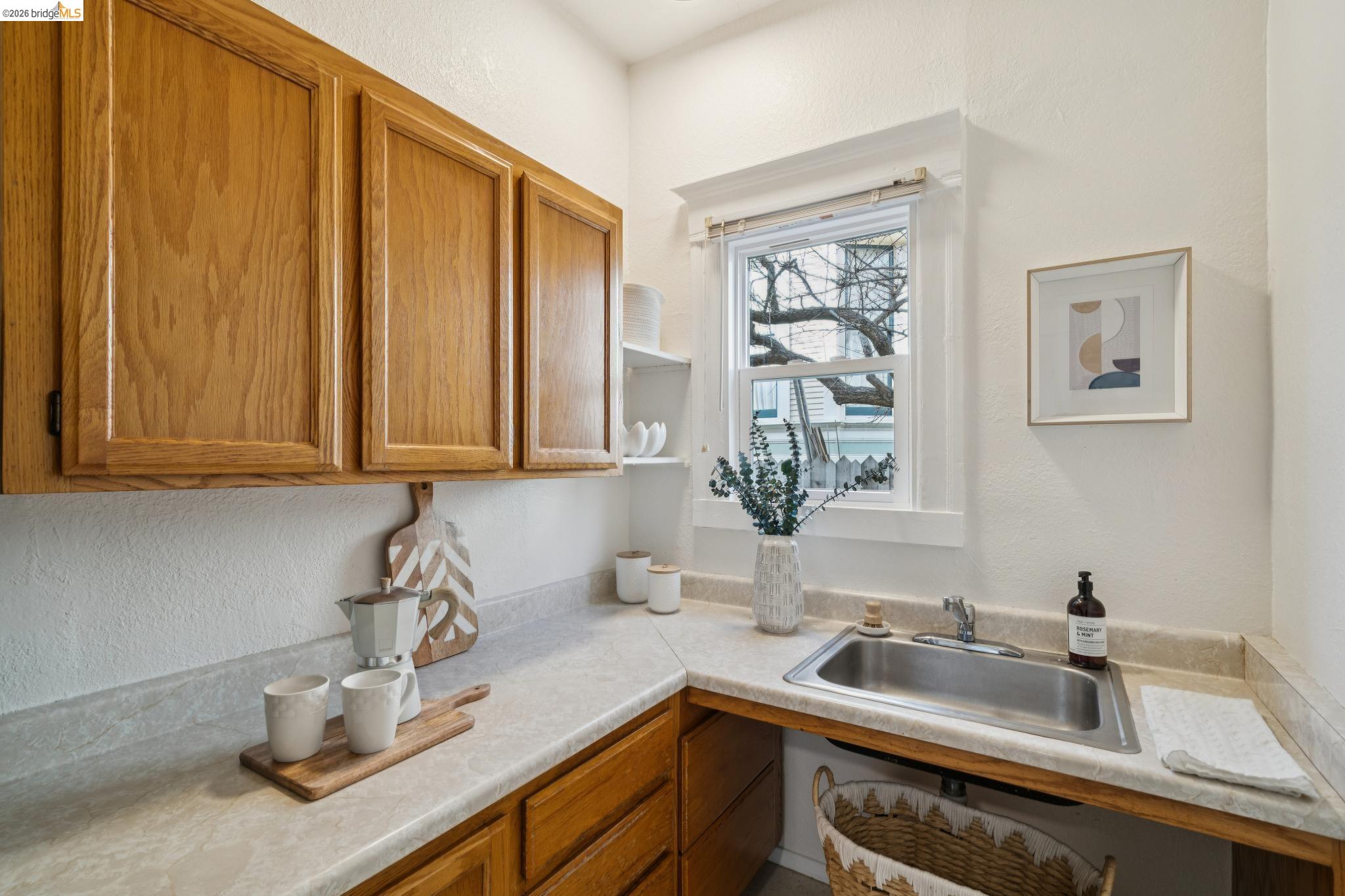 2923 Wheeler Street Berkeley, CA 94705 - Photo 5 of 28 Kitchen featuring wood finish cabinetry, a textured wall, open shelves, and light countertops