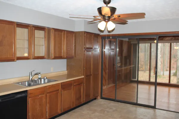 a kitchen with stainless steel appliances granite countertop a sink a window and cabinets