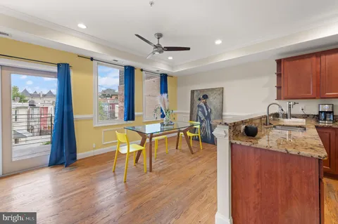 a view of a kitchen with kitchen island a large counter top space a sink stainless steel appliances and cabinets
