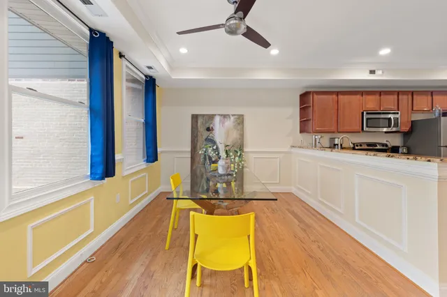 a view of a kitchen with kitchen island wooden floor and stainless steel appliances