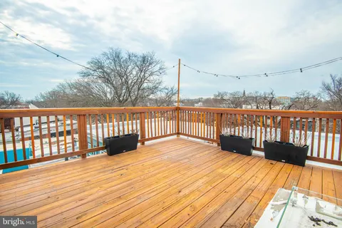 a view of balcony with wooden floor and fence