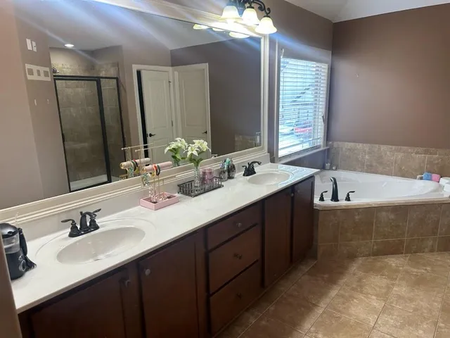 a bathroom with a sink double vanity mirror and a bathtub