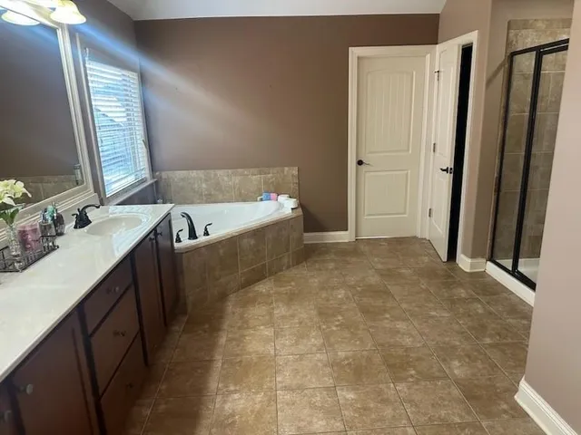 a bathroom with a tub sink and mirror
