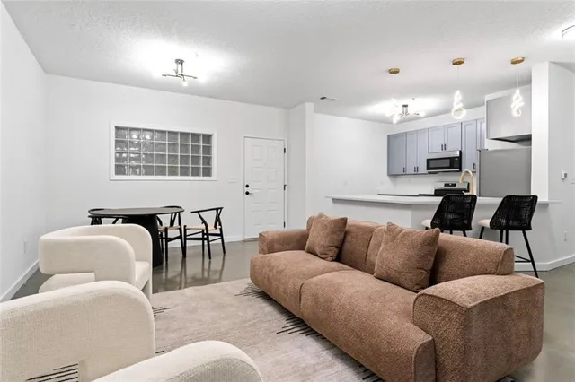 a living room with furniture and kitchen view