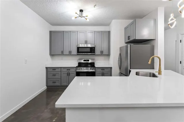 a kitchen with stainless steel appliances a refrigerator sink and microwave