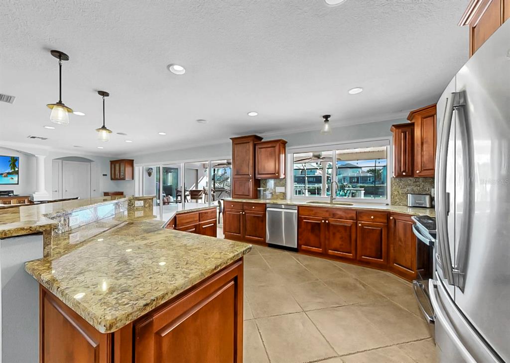 6317 Cocoa Lane Apollo Beach, FL 33572 - Photo 24 of 63 a kitchen with stainless steel appliances granite countertop a stove oven and a refrigerator