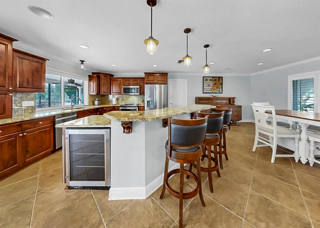 6317 Cocoa Lane Apollo Beach, FL 33572 - Photo 25 of 63 a kitchen with stainless steel appliances granite countertop a stove a sink a dining table and chairs with wooden floor