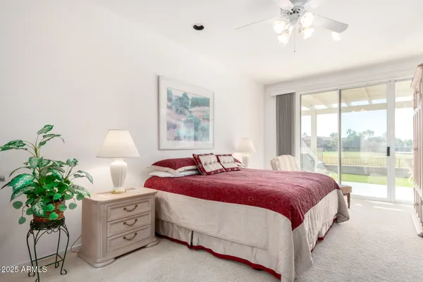 a spacious bedroom with a bed and a chandelier