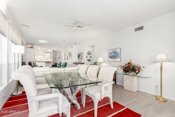 a kitchen with stainless steel appliances kitchen island granite countertop a table chairs and a refrigerator