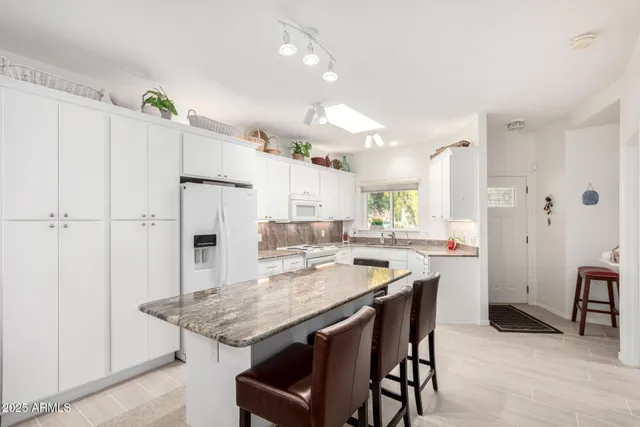 a large white kitchen with a stove a sink dishwasher and a refrigerator