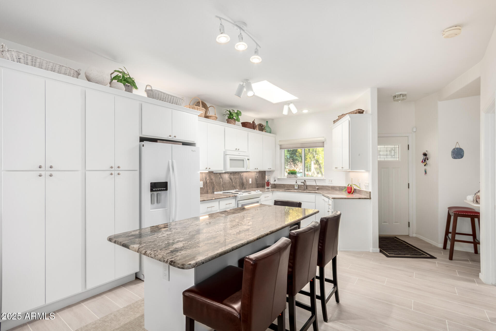5445 East McKellips Road, Unit 28 Mesa, AZ 85215 - Photo 9 of 39 a kitchen with stainless steel appliances kitchen island granite countertop a table chairs and a refrigerator